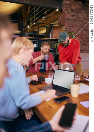 Team reviewing content together in relaxed coworking environment. Team reviewing content together in relaxed coworking environment. 134377245