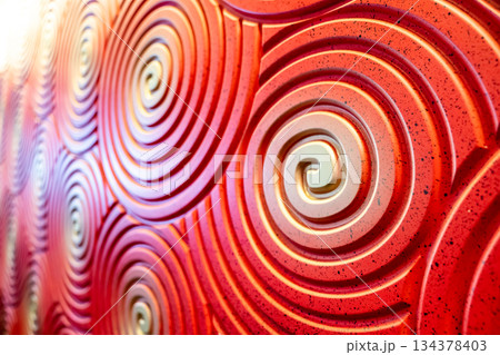 The walls are colored red, orange, and yellow and have spiral-like swirl lines. The walls are colored red, orange, and yellow and have spiral-like swirl lines. 134378403