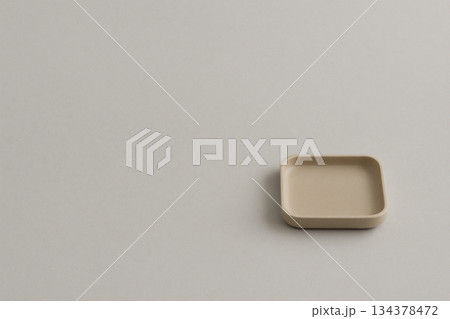 ベージュ背景に置かれた小さな木製トレイのミニマル構成 134378472