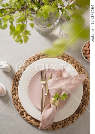 Easter table setting with bunny, pink plate and pastel eggs 134378564