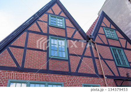 Historic brick house with green windows in a town 134379453