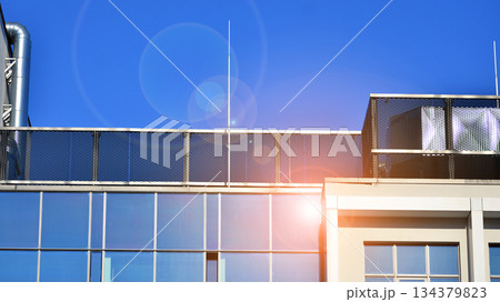 Office building in the evening with lightened workspaces. Modern, glazed skyscraper in financial district. Late hours in the office. 134379823