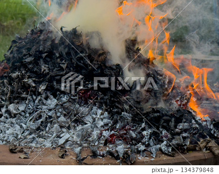dangerously hot orange and red flames with dense black smoke consuming wood and embers dangerously hot orange and red flames with dense black smoke consuming wood and embers 134379848