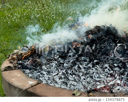 dangerously hot orange and red flames with dense black smoke consuming wood and embers dangerously hot orange and red flames with dense black smoke consuming wood and embers 134379875