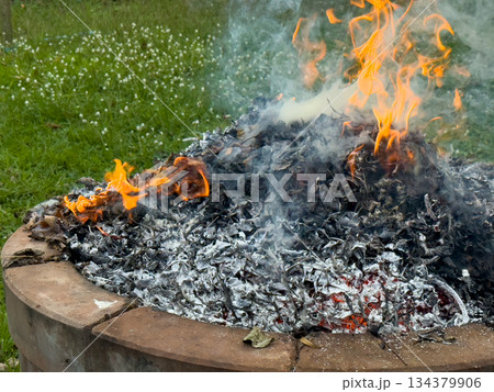 dangerously hot orange and red flames with dense black smoke consuming wood and embers dangerously hot orange and red flames with dense black smoke consuming wood and embers 134379906