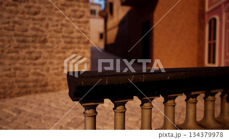 A quiet cobblestone alleyway just after sunset. Warm light illuminates the stone walls, creating a peaceful atmosphere. The distant buildings add to the cozy charm of the setting. 134379978