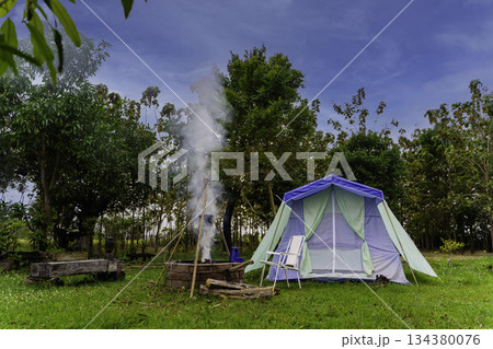 Nighttime camping tent in a forest clearing surrounded by nature 134380076