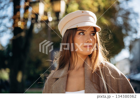 In white hat. Beautiful woman is outdoors in the town In white hat. Beautiful woman is outdoors in the town 134380362
