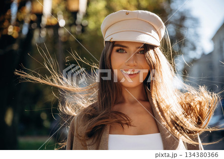 Smiling, cheerful facial expression. Beautiful woman is outdoors in the town 134380366