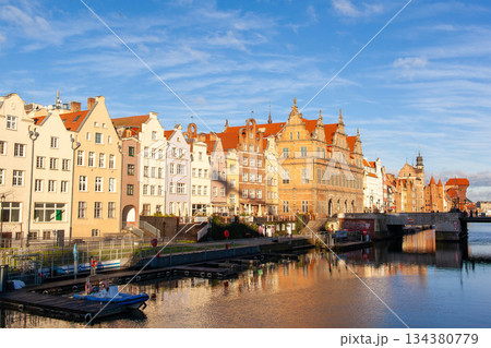 Historic buildings line the waterfront in Gdansk with clear skies above 134380779