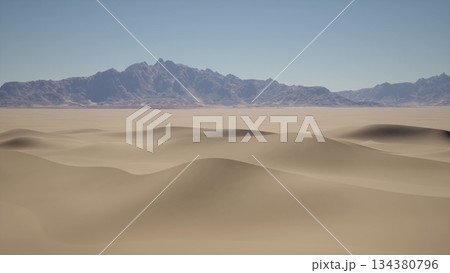 Golden sand dunes roll across the horizon, with mountains gently rising in the distance. The bright blue sky contrasts beautifully with the warm tones of the desert. A serene and tranquil scene. Golden sand dunes roll across the horizon, with mountains gently rising in the distance. The bright blue sky contrasts beautifully with the warm tones of the desert. A serene and tranquil scene. 134380796