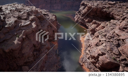Breathtaking scene captures the winding river snaking through rugged rocky canyons during a tranquil day. The sunlight glimmers on the waters surface, highlighting natures beauty. 134380895