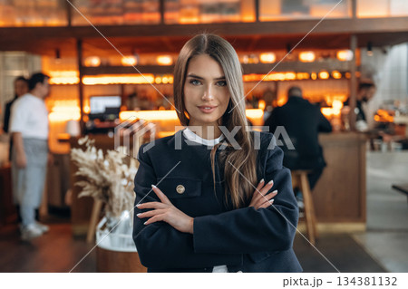 People are behind at background. Restaurant owner or manager is standing indoors People are behind at background. Restaurant owner or manager is standing indoors 134381132