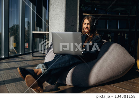 Woman is sitting and working by using laptop 134381159