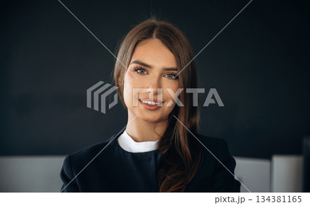 Cheerful beautiful woman is standing indoors 134381165