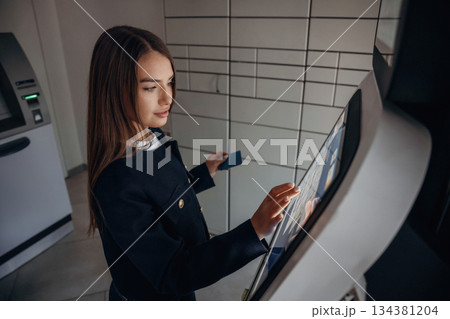 Woman is using banking terminal indoors 134381204