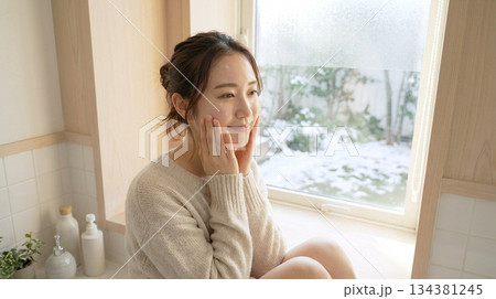 化粧水後にほのかに潤う20代日本人女性｜冬の朝・少し引いたスキンケアCM風 134381245