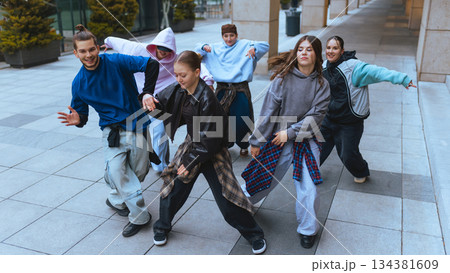 Group of dancers moving in sync in open city space. 134381609