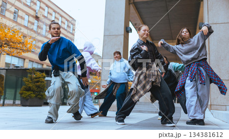 Hip hop dancers rehearsing routine together in urban location. 134381612