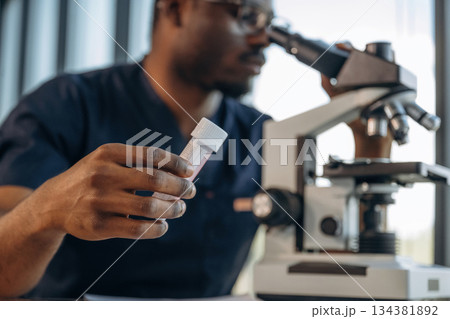 Doing research. Scientist is working indoors, microscope is on the table 134381892