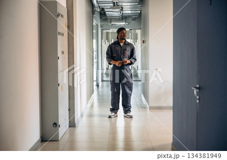 In the corridor. Repairman is indoors in the modern office 134381949