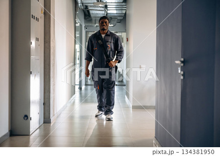 In the corridor. Repairman is indoors in the modern office 134381950