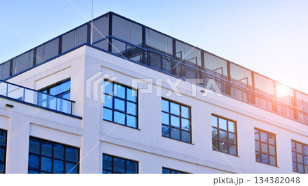 Office building in loft style. Facade of commercial office with windows. White walls of an industrial building. 134382048