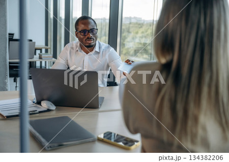 By the laptop. Two business people are working together in the office By the laptop. Two business people are working together in the office 134382206