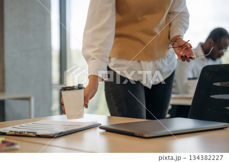 Woman is with cup of drink. Two business people are working together in the office 134382227
