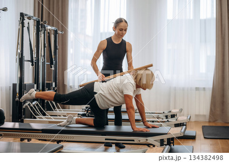 Back exercise. Female trainer is helping old woman to exercise 134382498
