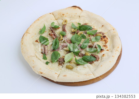 Tasty pizza with anchovies and basil on cream sauce on wooden board on white background 134382553