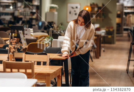 Woman is in the shop with decoration, indoors Woman is in the shop with decoration, indoors 134382870