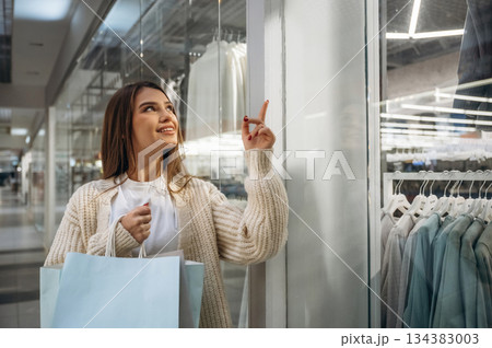 Thinking what to buy. Beautiful woman is in the mall, conception of shopping 134383003
