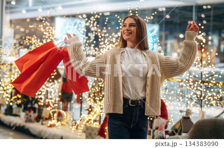 Joy and happiness. New year shopping and presents. Woman is near the Christmas tree Joy and happiness. New year shopping and presents. Woman is near the Christmas tree 134383090