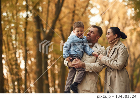Happy family are together in the autumn forest near the road 134383524