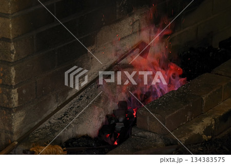 刀鍛冶の炉で燃え上がる炎と火花 刀鍛冶の炉で燃え上がる炎と火花 134383575