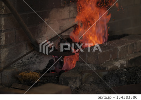 刀鍛冶の炉で燃え上がる炎と火花 134383580