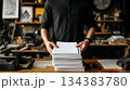 Man Handling Large Stack of White Paper on Desk 134383780