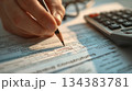 Hand Writing on Document with Calculator and Pencil 134383781