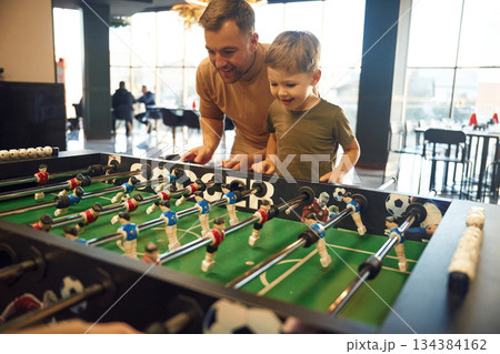 Conception of entertainment. Father and son are playing table football game indoors 134384162