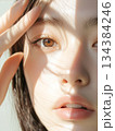 美肌で綺麗な若いアジア人女性の顔半分にクローズアップした美容・ファッション撮影ショット。光と影がおし 134384246