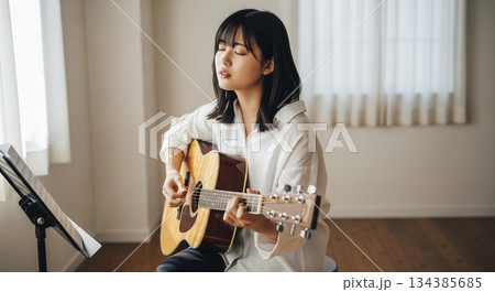 アコースティックギターを弾く女性 134385685