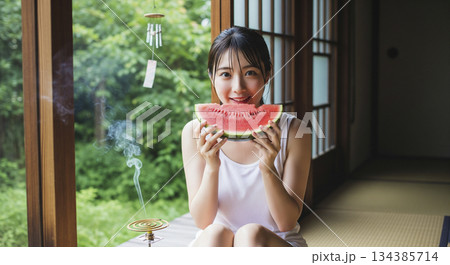 伝統的な日本家屋の縁側でスイカを食べる女性 134385714