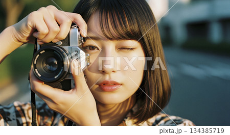 ヴィンテージフィルムカメラを持つ女性 134385719