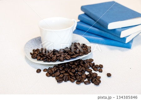 読書とコーヒーをイメージした白いカップとコーヒー豆 読書とコーヒーをイメージした白いカップとコーヒー豆 134385846
