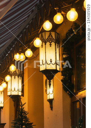 Nighttime Christmas lights decorate a building with warm glow for the festive season 134385929