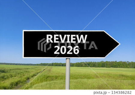 Review 2026 symbol. Concept words Review 2026 on beautiful black road sign. Beautiful green grass field forest and blue sky background. Business and review 2026 concept. Copy space. 134386282