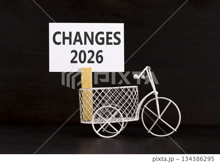 Changes 2026 symbol. Concept words Changes 2026 on beautiful white paper on wooden clothespin. Beautiful black background. Beautiful miniature bicycle. Business and changes 2026 concept. Copy space. Changes 2026 symbol. Concept words Changes 2026 on beautiful white paper on wooden clothespin. Beautiful black background. Beautiful miniature bicycle. Business and changes 2026 concept. Copy space. 134386295
