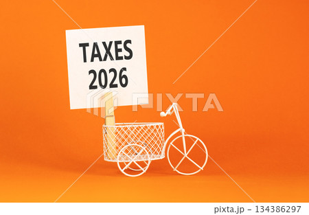 Taxes 2026 symbol. Concept words Taxes 2026 on beautiful white paper on wooden clothespin. Beautiful orange background. Beautiful miniature bicycle. Business taxes 2026 new year concept. Copy space. Taxes 2026 symbol. Concept words Taxes 2026 on beautiful white paper on wooden clothespin. Beautiful orange background. Beautiful miniature bicycle. Business taxes 2026 new year concept. Copy space. 134386297