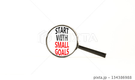 Start with small goals symbol. Concept words phrase Start with small goals in beautiful black magnifying glass. Beautiful white background. Business Start with small goals concept. Copy space. 134386988